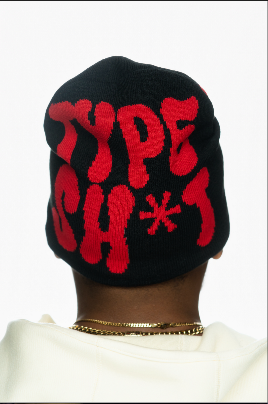 Black beanie with bold red text reading "TYPE SH*T" viewed from the back, worn by a person.